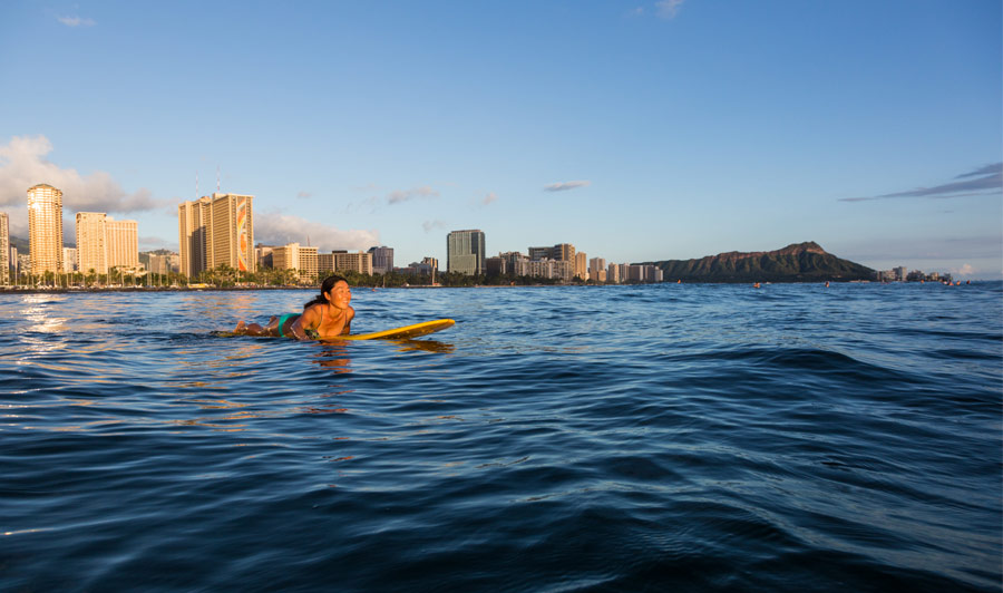 Surfer vor der Skyline von Waikiki, Oahu
